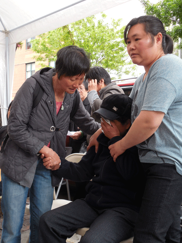 Family members comforted Wen Hui Ran’s sobbing widow at the memorial. Photo by Gerard Flynn